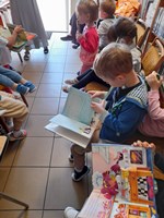 Dzieci przeglądają kolorowe książeczki.